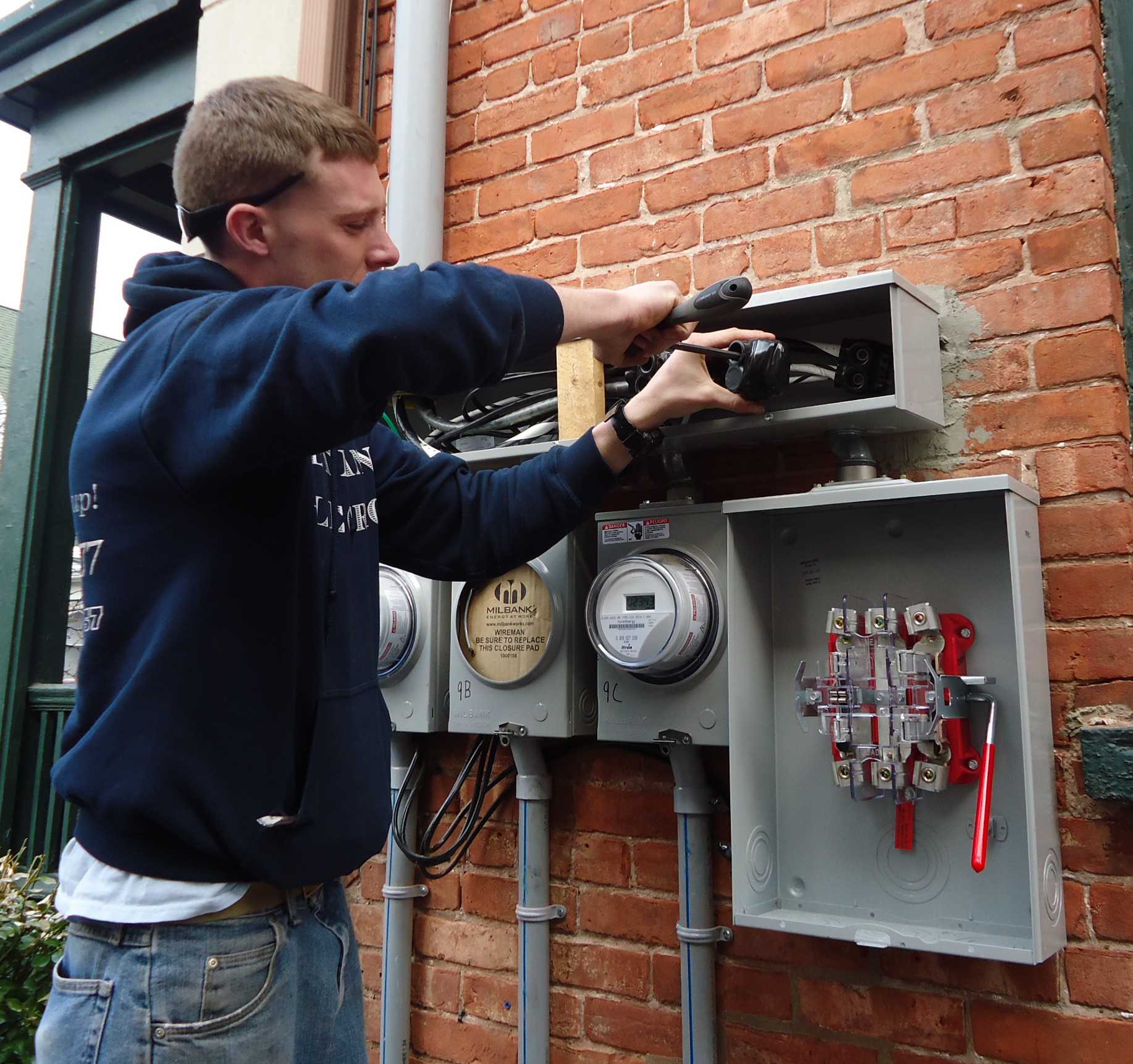 Electrician_installing_outdoor_connections_on_multifamily_house_compressor